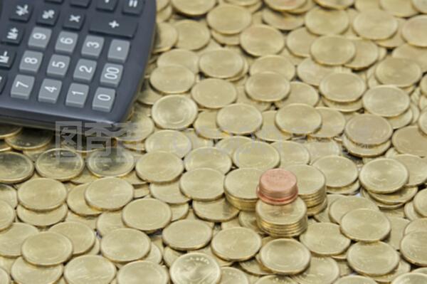 一堆金幣上有計(jì)算器的銅幣