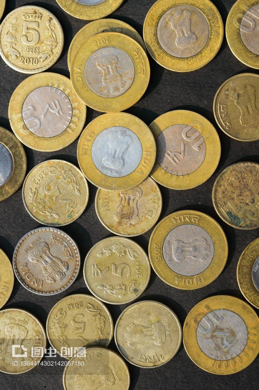 金色印度盧比硬幣貨幣在鄉村地板上的混合。全幀。桌面視圖。垂直。商業金融和金融投資背景。特寫
